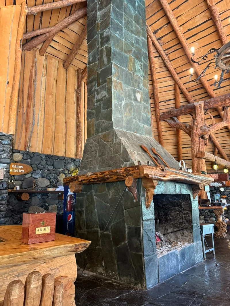 Chimenea de piedra y estructura de madera en Los Mañihuales