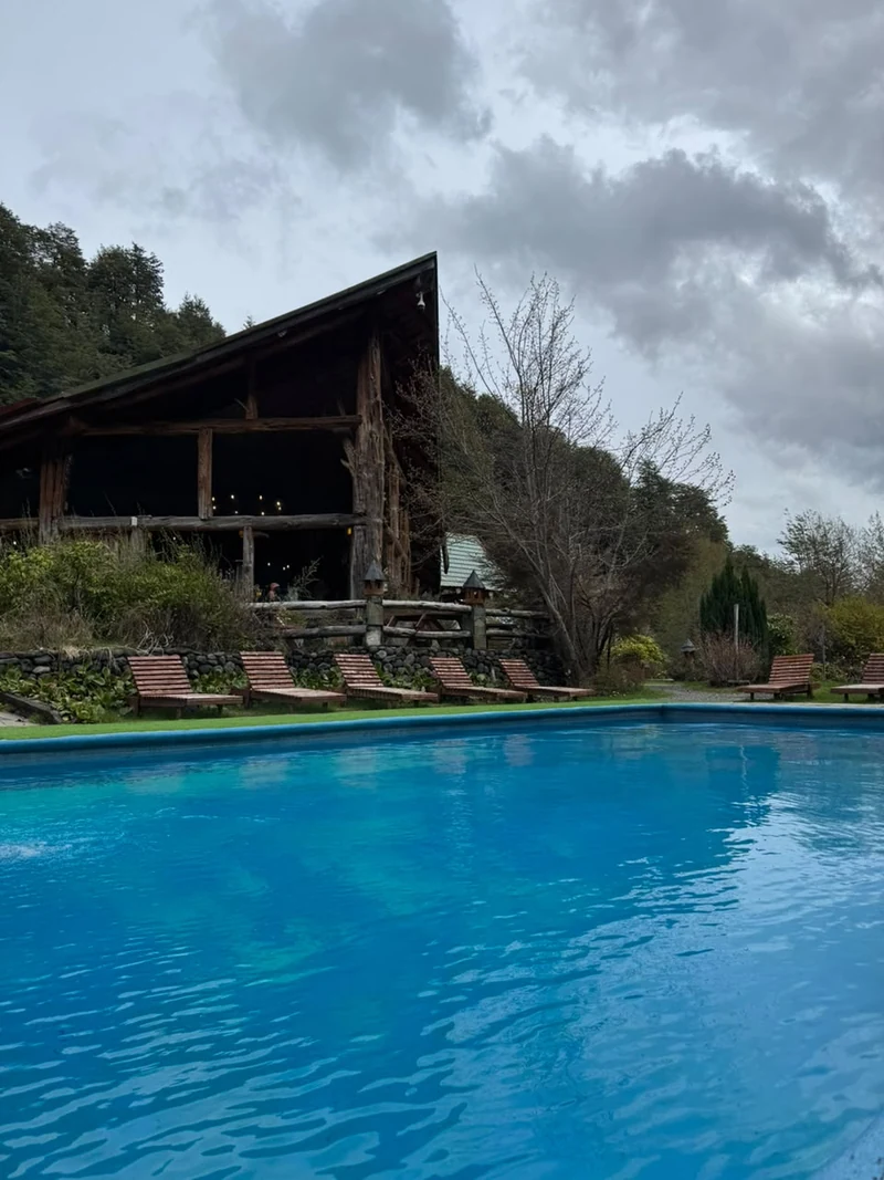 Piscina exterior de Termas Vergara frente a una construcción de madera