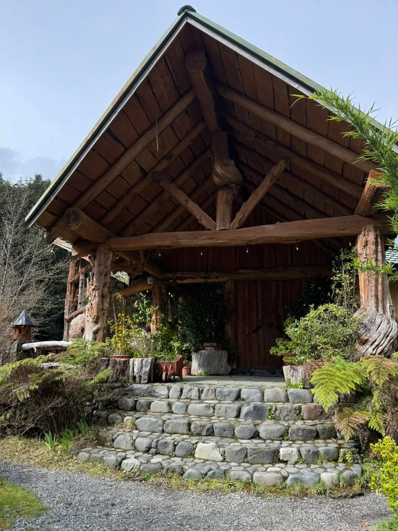 Entrada de madera y piedra al restaurante Los Mañihuales